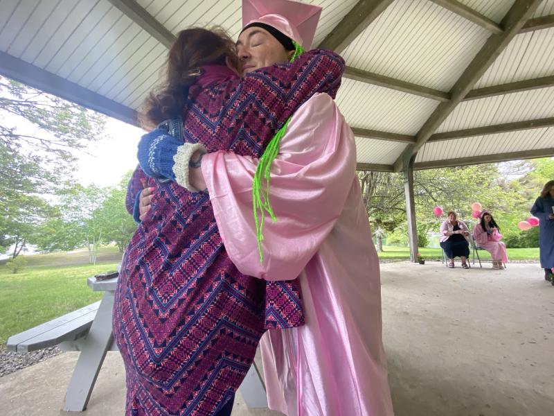 Rines hugs Administrative Assistant Katy Winslow after presenting her with a geranium in thanks. ISABELLE CURTIS/Boothbay Register