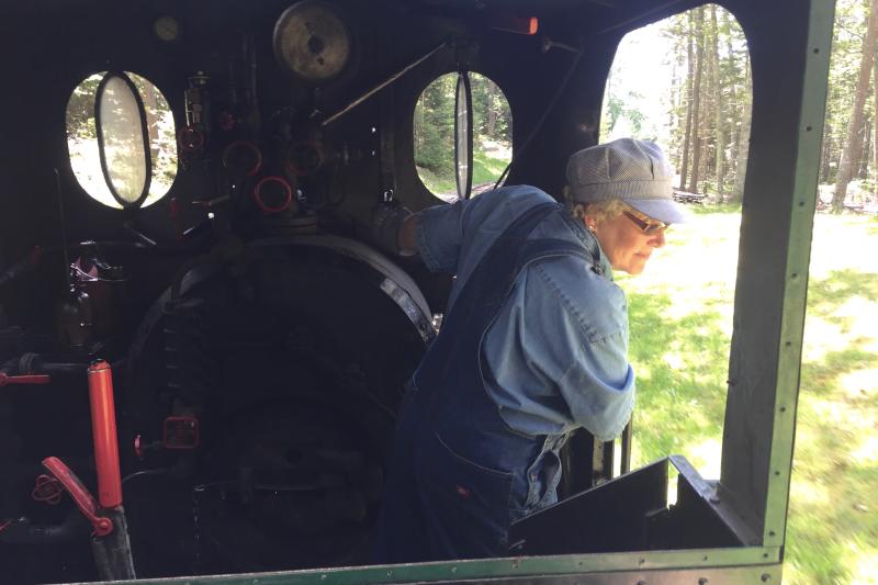 Cathy Orne watches the train as she drives it along the railway village track. FRITZ FREUDENBERGER/Boothbay register