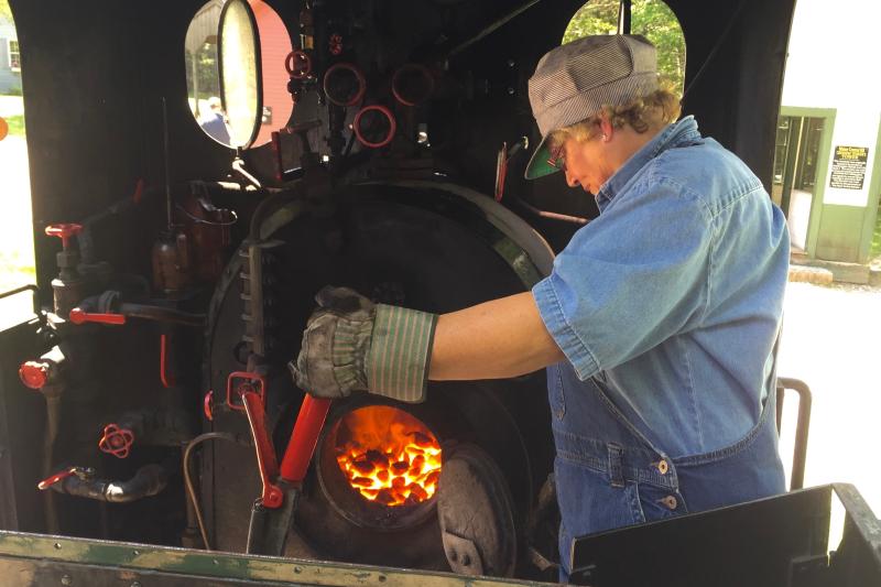 Cathy Orne examines the boiler engine coal fire. FRITZ FREUDENBERGER/Boothbay register