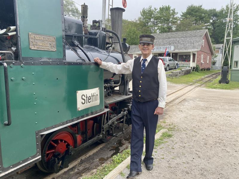 Roberto Forrest, volunteer conductor and engineer, poses with the museum’s famous 1934 train. ISABELLE CURTIS/Boothbay Register