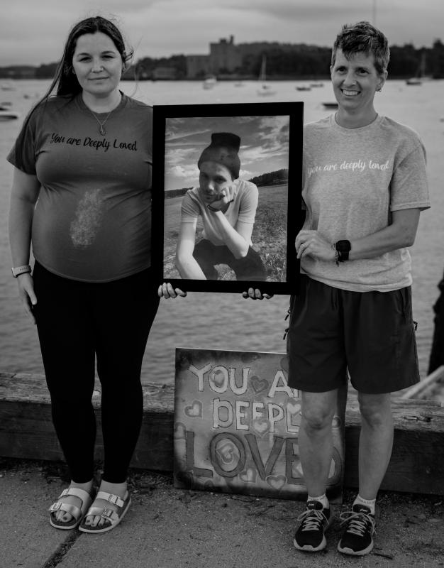 Wiscasset’s Taylor family lost Alex Taylor to drug overdose in 2020 at the age of 19. In the photo, from the ‘Lights of Lincoln County’ exhibit, his sister, Chelsea Taylor, left, and his mother, Deb Taylor, hold his photo with the refrain, “You are deeply loved,” which became a shared sentiment throughout the community after his passing. Photos from the exhibit by Charles Richards, part of the 716 Candles Project, will be on view during Wiscasset Art Walk, Thursday, Aug. 31, 5-8 p.m. Charles Richards photo