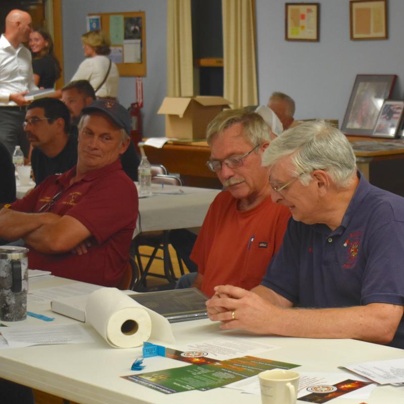 David Pratt, Richard Spofford and Paul Mayotte look over one of Spofford’s awards. FRITZ FREUDENBERGER/Boothbay Register