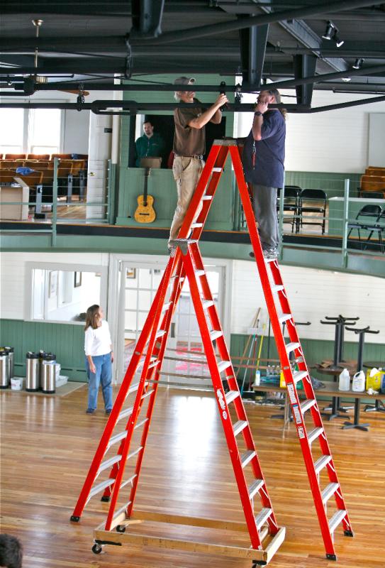 Steve Malcom and Mark Stover hang lights for the 2003 Jackson Browne benefit concert. Cathy Sherrill supervises from below. File photo