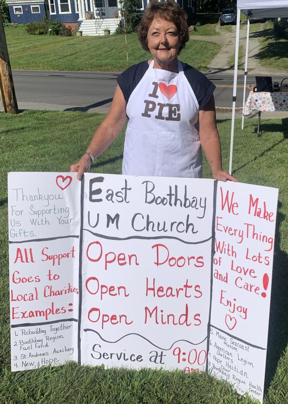 Sara Kerr displays a message board Aug. 12 showing bake sale customers the charities that benefit from the East Boothbay United Methodist Women’s bake sale. BILL PEARSON/Boothbay Register