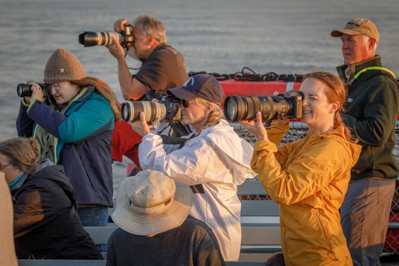 Some of the 30 photographers on the annual Sunrise Lighthouse cruise take aim at a scene. Mike Leonard photo