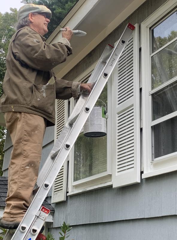 John Seitzer of Boothbay Harbor scraped paint and assisted in repainting a Wiscasset Road home Sept. 23 as part of a Rebuilding Together Lincoln County volunteer project. BILL PEARSON/Boothbay Register