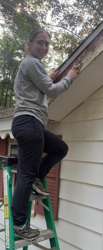 Laura Sofen of Boothbay Harbor grabbed a paint scraper and brush to assist with an Old Trevett Road house painting job Sept. 23 as part of Rebuilding Together Lincoln County’s volunteer project. BILL PEARSON/Boothbay Register