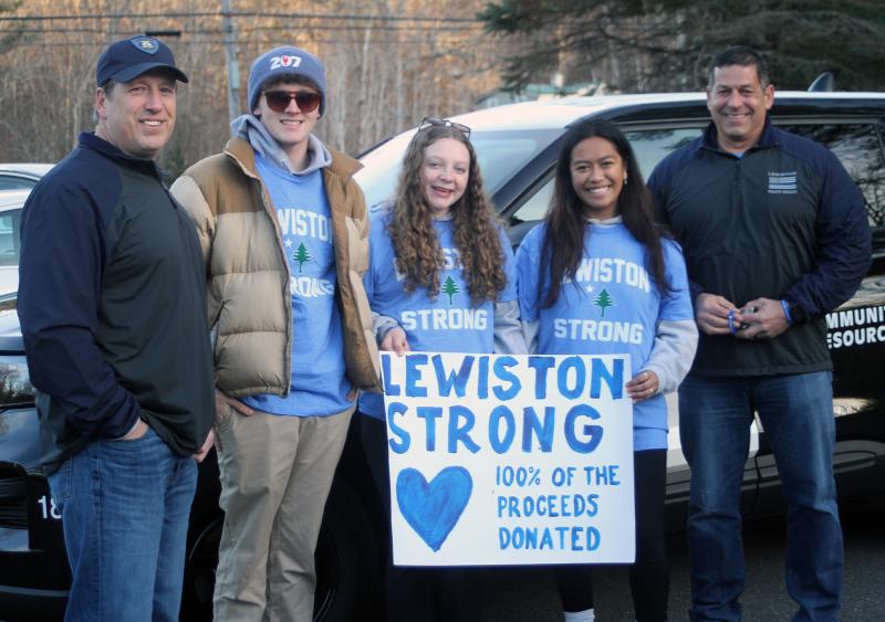 Prior to the start of the Lighted Fire Truck Parade on Saturday afternoon, Nov. 25, representatives of the Boothbay Region High School Rotary Interact Club made presentations to the Lewiston Police Department. Here, LPD’s Chief David St. Pierre, right, and Lt. Trevor Campbell stand with Colby Allen, Suzie Edwards and Ariel Alamo of Interact. The club raised $1,000 through donations and the sale of “Lewiston Strong” wrist bands for victims of the Oct. 25 mass shooting in Lewiston. The club donated several of the wrist bands to the Lewiston officers as well. The students’ T-shirts were provided by Boothbay Harbor Police Officer Larry Brown, a former Lewiston police officer. STEVE EDWARDS/Boothbay Register