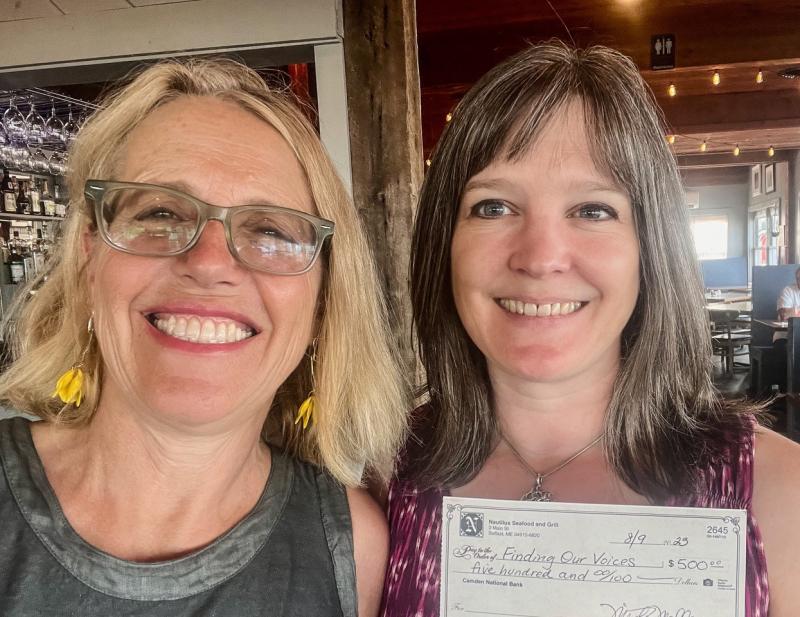 Patrisha McLean, CEO/Founder of Finding Our Voices, with Misty Mallar of Nautilus Seafood and Grill in Belfast. The $500 donation to Finding Our Voices represents 20% of sales of 250 slices of limoncello cake sold during July. Photo by Patrisha McLean