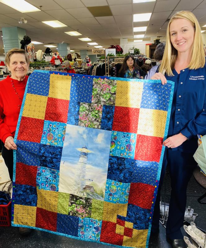 Melissa Brown, LincolnHealth Nurse Mgr. Oncology & Infusion services, right, accepts delivery of 20 quilts and dozens of infusion cushions handcrafted by St. Andrews Auxiliary Sewing Group for patients undergoing chemotherapy. Auxiliary cashier, Mary Pierce is on hand to train a new cashier. Displayed ‘Lighthouse’ quilt by Ann Hedgcock.Courtesy photo