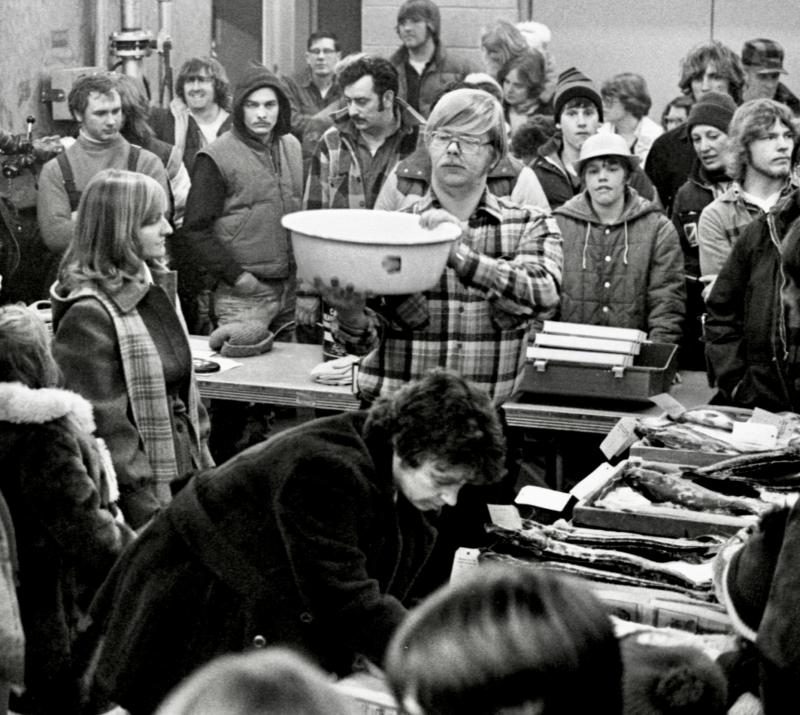 Fireman John Harvey of Wiscasset, shown holding the bowl that helped weigh in and judge the fish entries. That’s Ann Merry leaning over the scorer’s table where the fish entries were placed. PHIL DI VECE photo