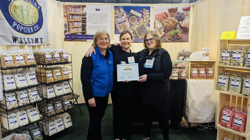 Julie Roberts, center, owner of Coastal Maine Popcorn holds her award. Courtesy of Cherie Scott