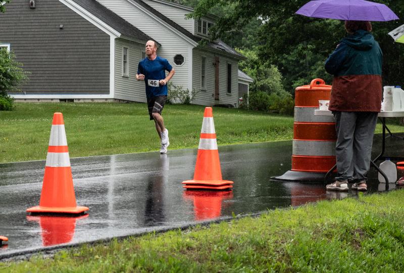 D.J. Kelly passes an aid station on his way to take the top prize for the 5K leg of the Edgecomb 250th Birthday Road Race on June 22. Volunteers helped man three aid stations along the course to provide water and assistance as needed. Bisi Cameron Yee photo