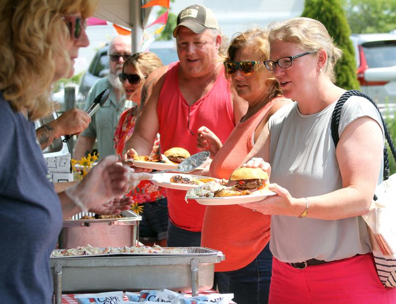 Mike Alley, left, Becky Alley and Maddie Kaler pick up their food at the barbecue. STEVE EDWARDS/Boothbay Register