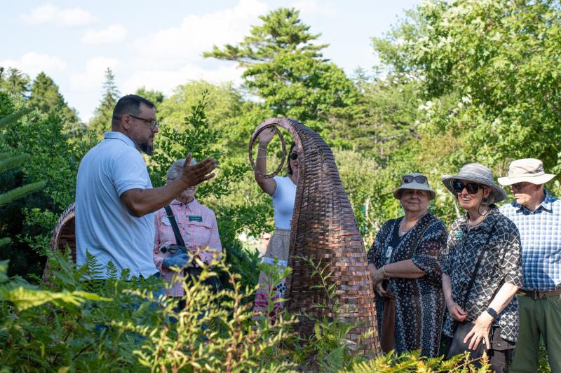Attendees look at the Shane Perley-Dutcher, Eci-Mahsosiyil/Fiddleheads sculptures (2024). Courtesy of Coastal Maine Botanical Gardens