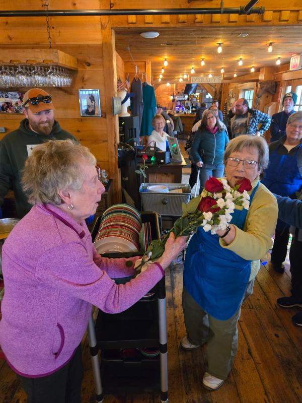 Dee Wright presents roses to Community Lunch volunteer Tancy Mitchell. Darrell Gudroe photo Dee Wright presents roses to Community Lunch volunteer Tancy Mitchell. Darrell Gudroe photo
