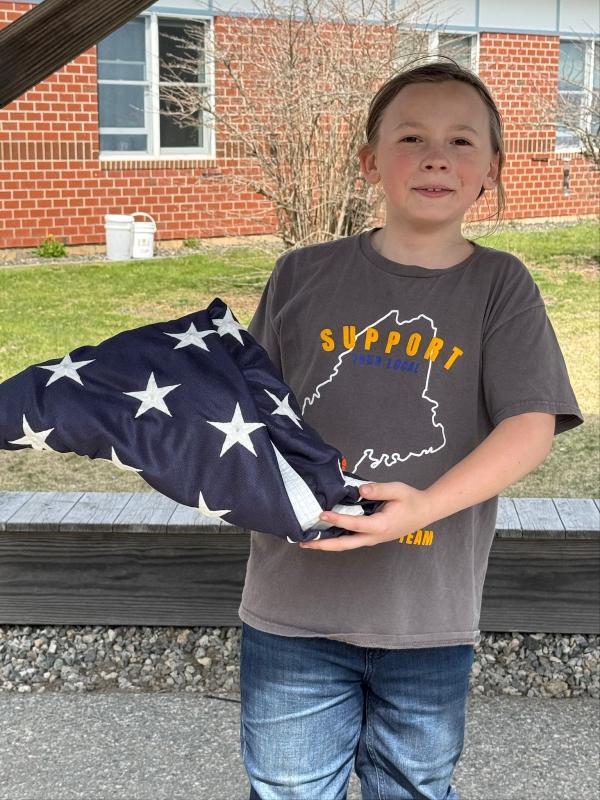Andrew, son of Amanda and Andy Main, displays the properly folded American flag, purchased two years ago with funds raised by the 6th grade class of 2023. Courtesy photo Andrew, son of Amanda and Andy Main, displays the properly folded American flag, purchased two years ago with funds raised by the 6th grade class of 2023. Courtesy photo