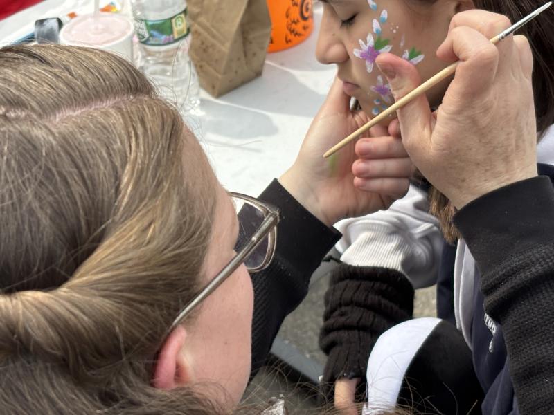 Gigi DeLisle paints spring flowers on a youngster's cheek. LISA KRISTOFF/Boothbay Register LISA KRISTOFF/Boothbay Register