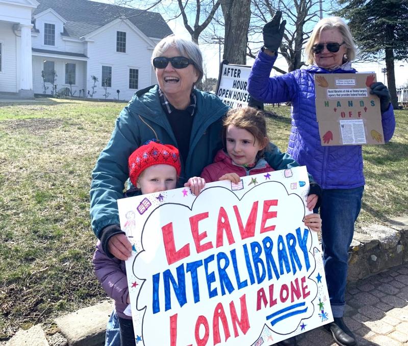 Rita Arnold and her granddaughters, June and Faye, protest the federal funding cuts to libraries nationwide. ISABELLE CURTIS/Boothbay Register Rita Arnold and her granddaughters, June and Faye, protest the federal funding cuts to libraries nationwide. ISABELLE CURTIS/Boothbay Register