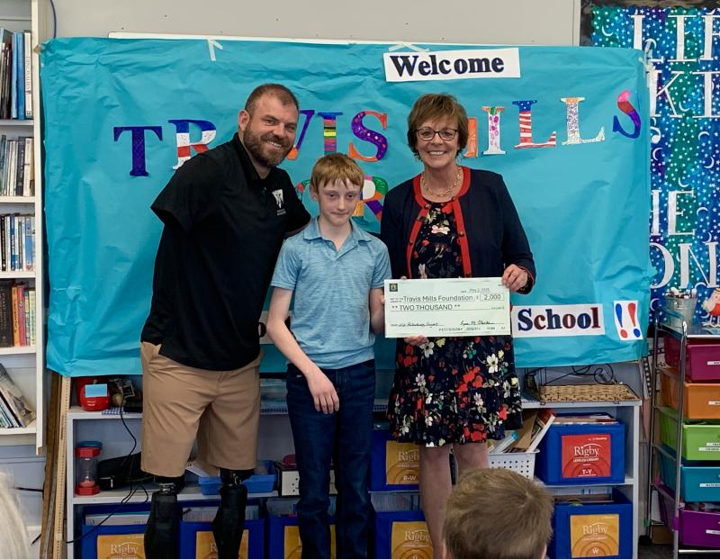 6th grader Duncan Scott helps present the ceremonial check to his chosen charity, the Travis Mills Foundation. Pictured: Travis Mills, Duncan Scott, and principal Lisa Clarke. ISABELLE CURTIS/Boothbay Register 6th grader Duncan Scott helps present the ceremonial check to his chosen charity, the Travis Mills Foundation. Pictured: Travis Mills, Duncan Scott, and principal Lisa Clarke. ISABELLE CURTIS/Boothbay Register