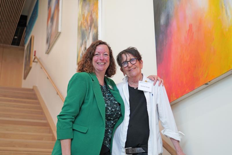Vice President for Research Beth Orcutt with Michel Droge in front of Droge’s work which is on display in the new center. 