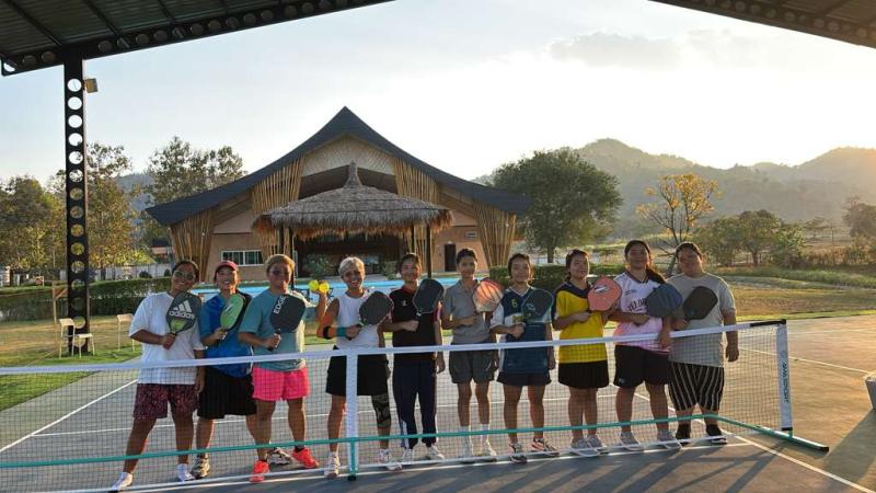 Wide-shot pickleball players at the net in front of Sala. Courtesy of FTD