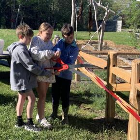 Rivers Healy, Lily Billings and Aiden Nunan cut a ceremonial ribbon May 22 to unveil the school's new compost system. ISABELLE CURTIS/Boothbay Register