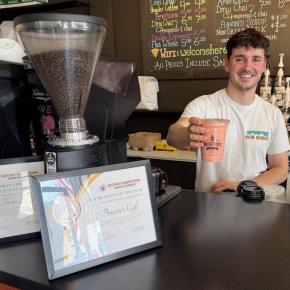 Florin Iuga serves up a smoothie at his shop Brisetto's Second Cup. Iuga is displaying his patriotism as America celebrates its 250th anniversary with giant 12-foot by15-foot American flag on his storefront. BILL PEARSON/Boothbay Register 