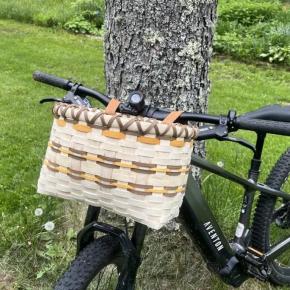 Workshop participants may choose to weave either a bike basket like this one, or a gathering basket with a wooden swing handle. Courtesy of Coastal Rivers