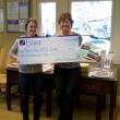 Abby Plummer, aka “Farm Abby” of the Morris Farm, left, accepts a check from Monique McRae, Wiscasset Branch Manager of The First for the Wiscasset Primary School’s garden project at the Morris Farm. Courtesy of The First