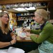 Teresa Simpson, left, talks with Alna Store co-owner Amy Preston, as Preston adds to a donation canister to help cover the stray dog’s medical costs. SUSAN JOHNS/Wiscassest Newspaper