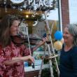 Liz Lannon, left, of Wiscasset on fiddle meets up with twig artist Susan Perrine of Woolwich outside Mac's Place during the art walk. SUSAN JOHNS/Wiscasset Newspaper