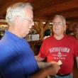 Dwight, left, and Duane Lewis look at the photos of themselves during their school days at the June 29 party at Robinson's Wharf. KEVIN BURNHAM/Boothbay Register