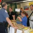 Boothbay Harbor Police Officer Larry Brown gets ready to help Dale Harmon and his son with the school supply list. KEVIN BURNHAM/Boothbay Register