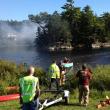 Firefighters wait on the mainland for a boat to be ferried out to the island in “The Marsh” in East Boothbay Saturday afternoon. JOE GELARDEN/Boothbay Register