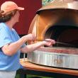 Shelly McLellan takes a wood-fired pizza out of her custom made oven. SUZI THAYER/Boothbay Register