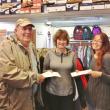 Janson’s Clothing Store owner Betty Maddocks (center) hands out gift certificates to Larry Oakes and Beth Raburn. 