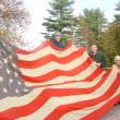 Wiscasset author Phil DiVece, left, Lincoln County Historical Association President Ed Kavanagh and longtime Wiscasset resident Bee King, now of East Boothbay, hold up an 1896 flag King’s grandmother sewed. King donated it to the historical association on October 28. SUSAN JOHNS/Wiscasset Newspaper