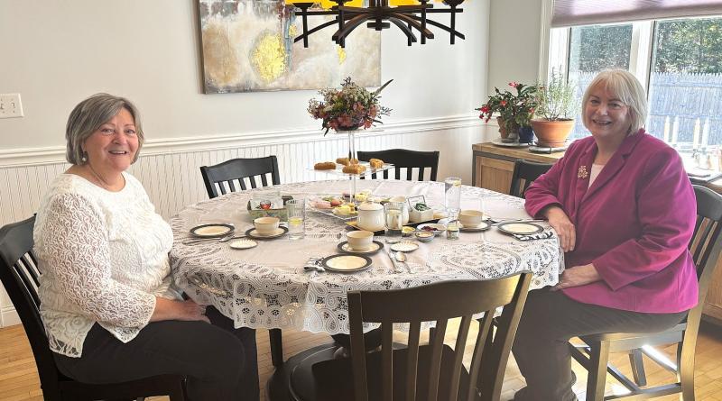 BRGC members Karen Iliades, left, and Cathy Fisher seated at Karen's table set with samplings of fare typically served at Afternoon Tea. LISA KRISTOFF/Boothbay Register