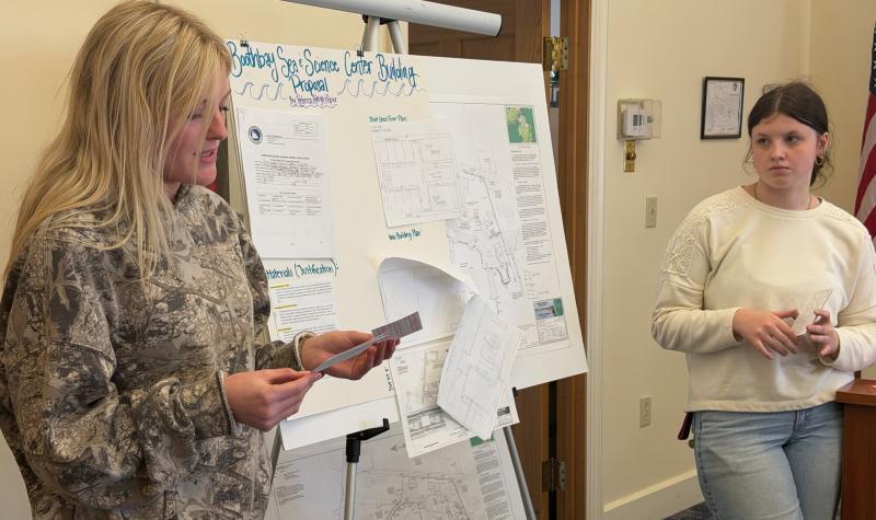 A high school class project resulted in providing the Boothbay Sea and Science Center with advice on combatting the impact of rising sea levels on its boat house and two educational buildings. Four groups of students provided their research and recommendations April 10 to Boothbay Planning Board Chairman Bruce Bowler and Code Enforcement Officer Dan Feeney at the municipal building. Pictured are Piper McKane, left, and Aileigh Johnson. BILL PEARSON/Boothbay Register