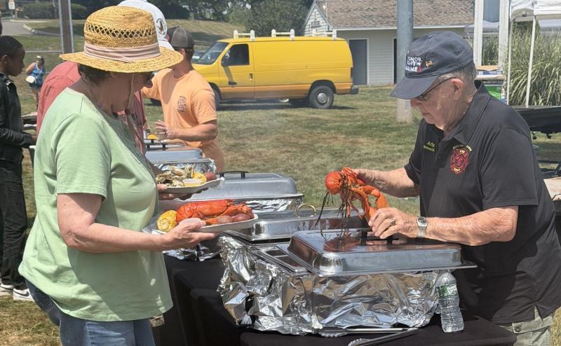 Boothbay Harbor fireman Arthur Richardson serves up a lobster during the Aug. 1 Lobster Bake. BILL PEARSON/Boothbay Register
