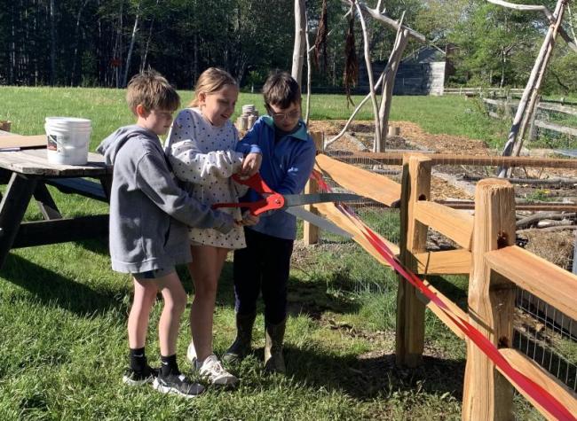Rivers Healy, Lily Billings and Aiden Nunan cut a ceremonial ribbon May 22 to unveil the school's new compost system. ISABELLE CURTIS/Boothbay Register