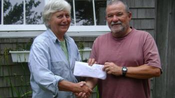 John Webster, proprietor of Orne’s Candy Store, gives $400 to Betsy Wing, treasurer of the Boothbay Region Food Pantry. 