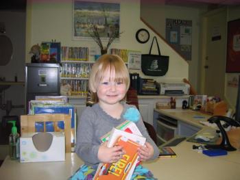 Audrey gathers some carefully selected books to read until she returns for Story Time next week.