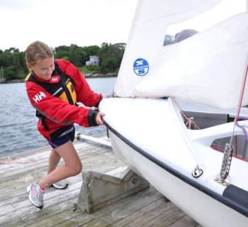 Madison Gaudette pushes in her 420 with the help of her skipper Jessica Murphy (not pictured). The Boothbay Harbor Yacht Club's Andy Holmes and Boothbay Region High School Club Sailing Team Head Coach Sally Lloyd said they would like to see the club affiliated with the high school. BEN BULKELEY/Boothbay Register Madison Gaudette pushes in her 420 with the help of her skipper Jessica Murphy (not pictured). The Boothbay Harbor Yacht Club's Andy Holmes and Boothbay Region High School Club Sailing Team Head Coach Sally Lloyd said they would like to see the club affiliated with the high school. BEN BULKELEY/Boothbay Register