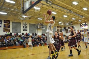 Evan Hepburn slices through two Monmouth defenders. BEN BULKELEY/Boothbay Register