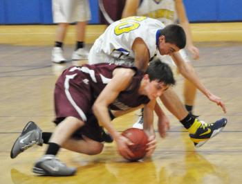 Evan Hepburn, center, battles with a Monmouth Mustang for a loose ball. 
