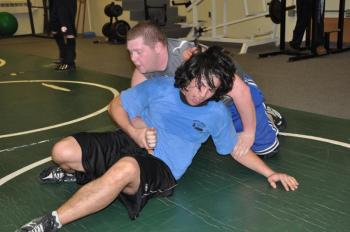 Boothbay Region High School's Antonio Maulolo, front, tries to get out of a hold during a February 11 wrestling practice at Lincoln Academy. Below: Howard Carter, left, puts Coach Don Waltz into a hold. BEN BULKELEY/Boothbay Register Boothbay Region High School's Antonio Maulolo, front, tries to get out of a hold during a February 11 wrestling practice at Lincoln Academy. BEN BULKELEY/Boothbay Register
