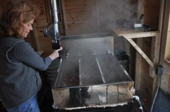 Finch checks boiling sap March 25 at Hidden Treasure Farm in Jefferson. BEN BULKELEY/Boothbay Register
