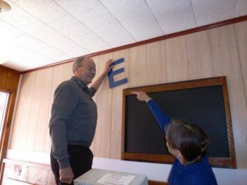 Peter and Nancy Gilchrist argue playfully about what angle the letters spelling Ebb Tide should hang on the wall. Below: Nancy Gilchrist, right, offers a St. Patrick’s Day cookie to Joyce Tomecko of Rhode Island while John Appleton looks on. KATRINA CLARK/Boothbay Register Peter and Nancy Gilchrist argue playfully about what angle the letters spelling Ebb Tide should hang on the wall. KATRINA CLARK/Boothbay Register
